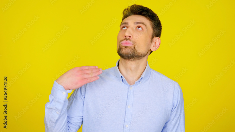 I'm fed up with this. Displeased bearded man in light blue shirt with hand near the neck on yellow background with copy space I'm fed up with this. Displeased bearded man in light blue shirt with hand near the neck on yellow background with copy space