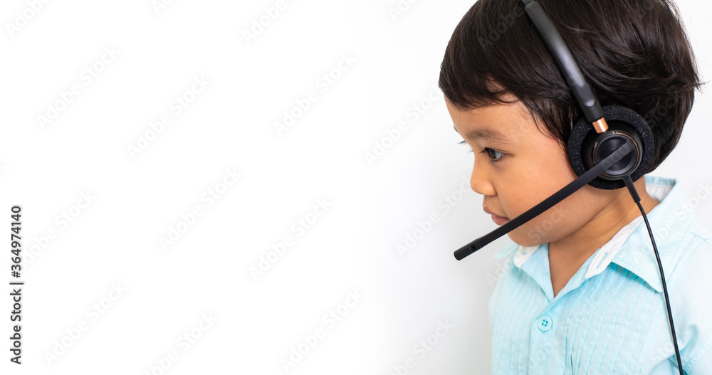 Child as a businessman in a video conference. Cute Asian boy in VOIP Helpdesk headset. Kid customer service center. Kid education and e-learning concept. Child as a businessman in a video conference. Cute Asian boy in VOIP Helpdesk headset. Kid customer service center. Kid education and e-learning concept.