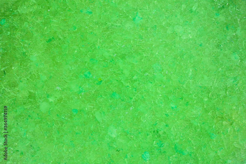 Abstract background, soft focus. Green aromatic sea salt in water. Top view.