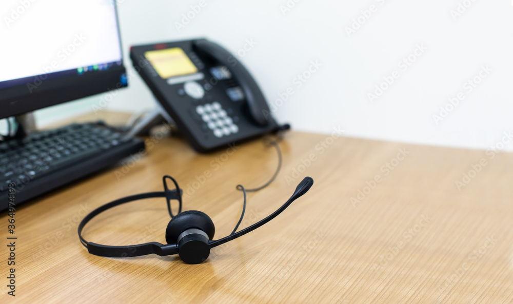 VOIP headset for callcenter on desk at customer service office. Communication support for sale support and telemaketing Helpdeskac VOIP headset for callcenter on desk at customer service office. Communication support for sale support and telemaketing Helpdeskac