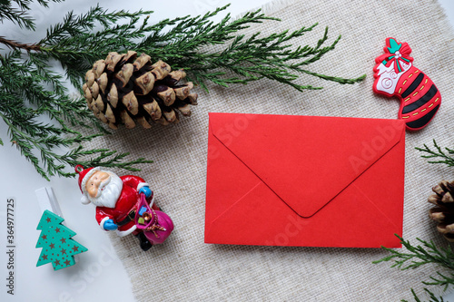 postcard mockup. spruce branch with cones, Christmas toys and a figure of Santa Claus on a white background. place for text. invitation. congratulation photo