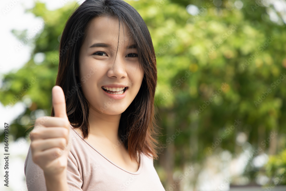 successful girl pointing thumb up; portrait of cheerful smiling woman pointing up approving, yes, ok, good, thumb up gesture; southeast asian woman young adult model successful girl pointing thumb up; portrait of cheerful smiling woman pointing up approving, yes, ok, good, thumb up gesture; southeast asian woman young adult model