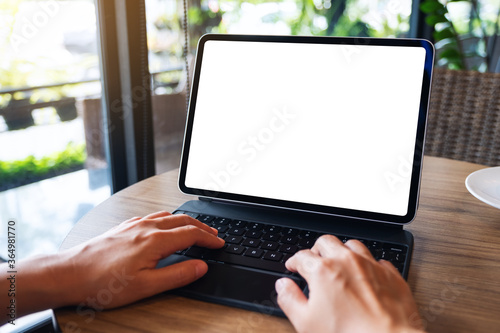 Mockup image of a woman using and typing on tablet keyboard with blank white desktop screen as a computer pc on the table