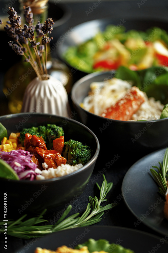 Various culinary dishes on a dark wooden table. Exquisite restaurant serve on dark dishes