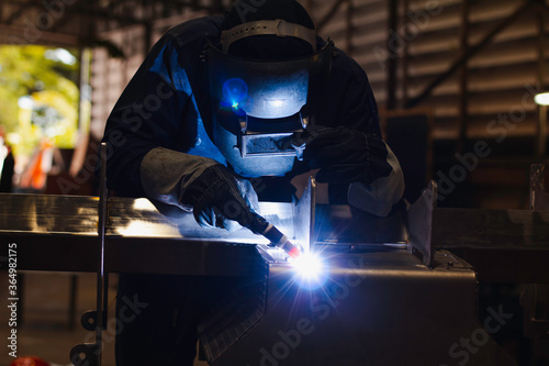 Metal workers use manual labor. Skilled welder. Factory workers making OT. Welder is welding the steel in the factory. welder Industrial automotive part in factory. © niwat