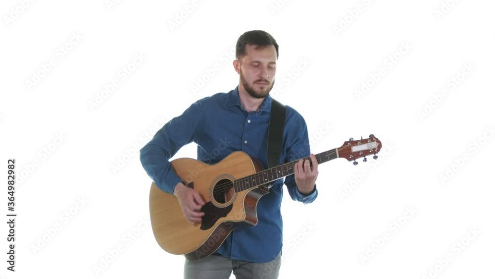 handsome man with a beard plays beautiful melody on an acoustic guitar. White background. Isolated. Medium long shot handsome man with a beard plays beautiful melody on an acoustic guitar. White background. Isolated. Medium long shot