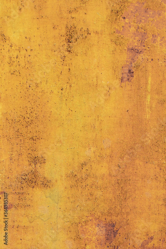 Old rusty metal surface with yellow and brown paint flaking and cracking texture. 