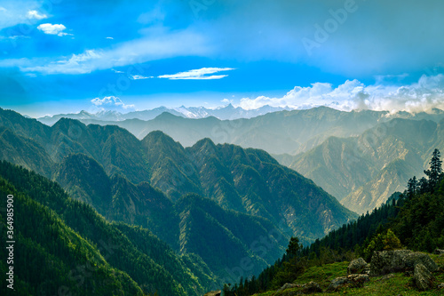 Mountain landscape with clouds, meadows. Himalayas peaks & alpine l from the trail of Sar Pass trek  Himalayan region of Kasol, Himachal Pradesh, India. photo