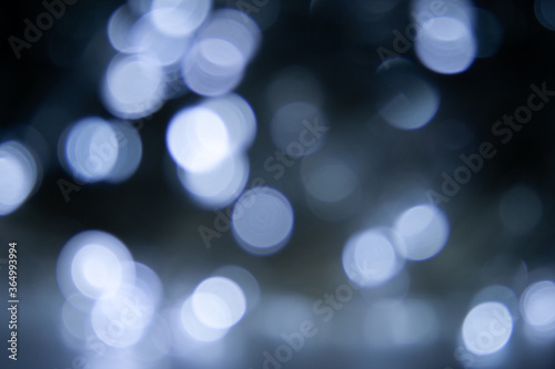 Blurred lights dark gray blue background. Abstract bokeh with soft light. Shiny festive christmas texture