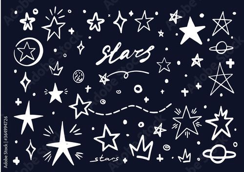 White star doodle on blue black sky. Abstract hand drawn scribble stars shape elements. Cartoon line marker sketch for text emphasis on chalck board background. Pen graphic highlight graffiti sketch photo