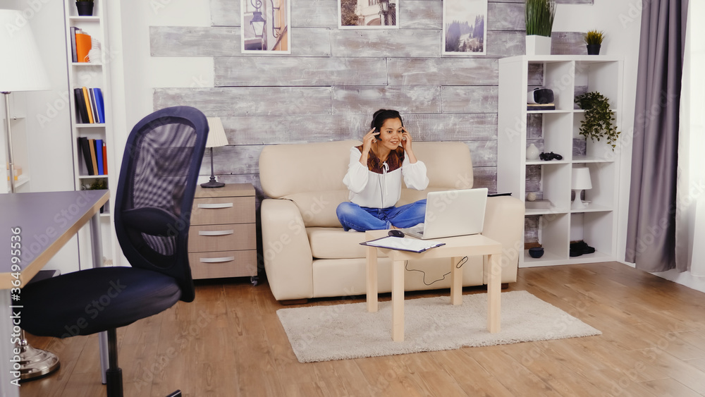 Woman in slow motion putting headphones during a video call while working from home. Woman in slow motion putting headphones during a video call while working from home.