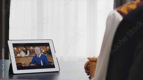 Happy woman talking with her father on a video call using tablet computer.