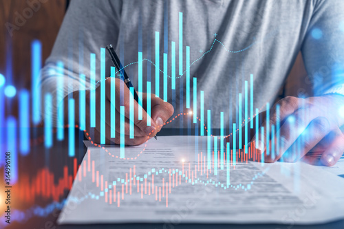 Double exposure of man signing contract and forex graph hologram. Blue infographic business chart. Concept of market investment. © VideoFlow