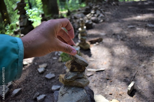 Hand placing a stone on a pile during a trekking