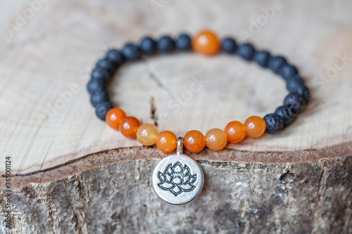 Karneol and lava mineral stone beads bracelet on wooden background photo