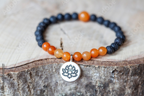 Karneol and lava mineral stone beads bracelet on wooden background