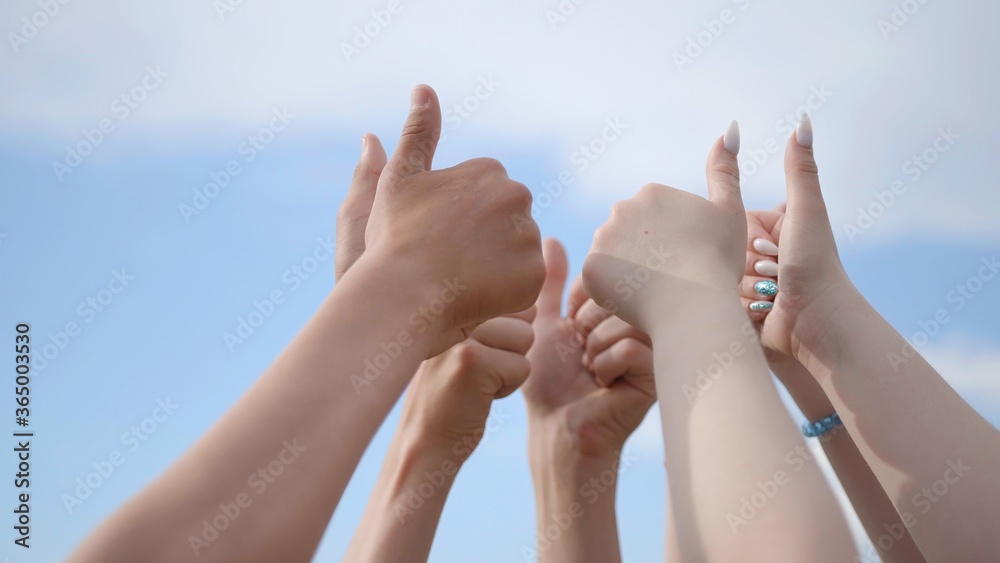 A group of friends raise their hands with their fingers up. A group of friends raise their hands with their fingers up.