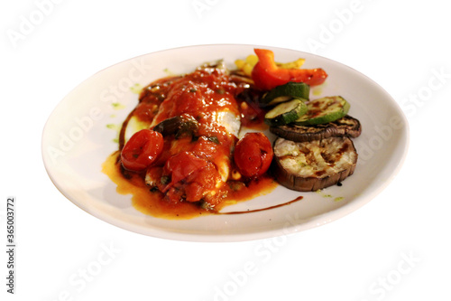 Filet de loup avec sauce rouge, tomates cerises et légumes grillé