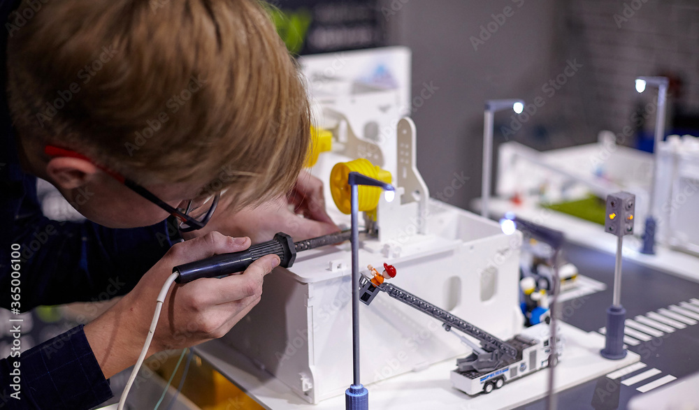 young engineer solders electronics components in smart home