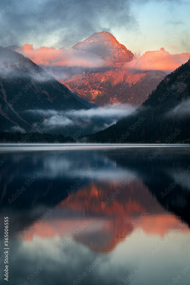Lake Plansee in Austria near Reutte Heiterwang at sunrise with morning light alpenglow on the mountain Thaneller