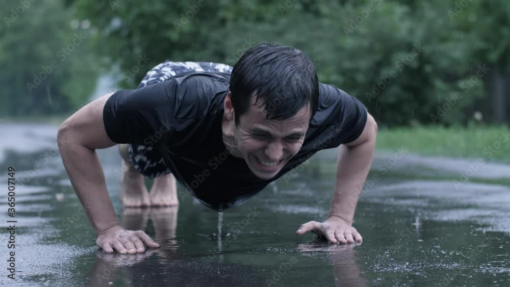 Man do push-ups at rain the street