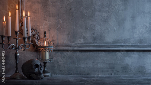 Mystical Halloween still-life background. Skull, candlestick with candles, old fireplace. Horror and witchery.