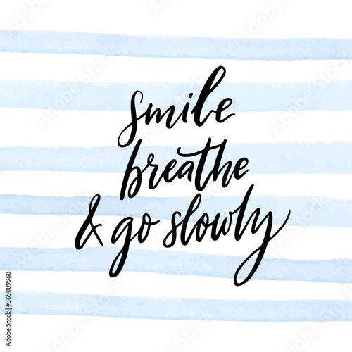 Smile, breathe and go slowly. Inspirational quote about calmness, mindfulness and slow life. White handwritten text on blue watercolor strips background. Motivational saying.