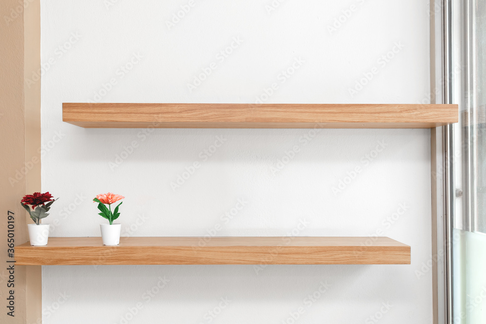 Flowers in a vase on a wooden shelfs, Wooden shelves on the wall. Flowers in a vase on a wooden shelfs, Wooden shelves on the wall.