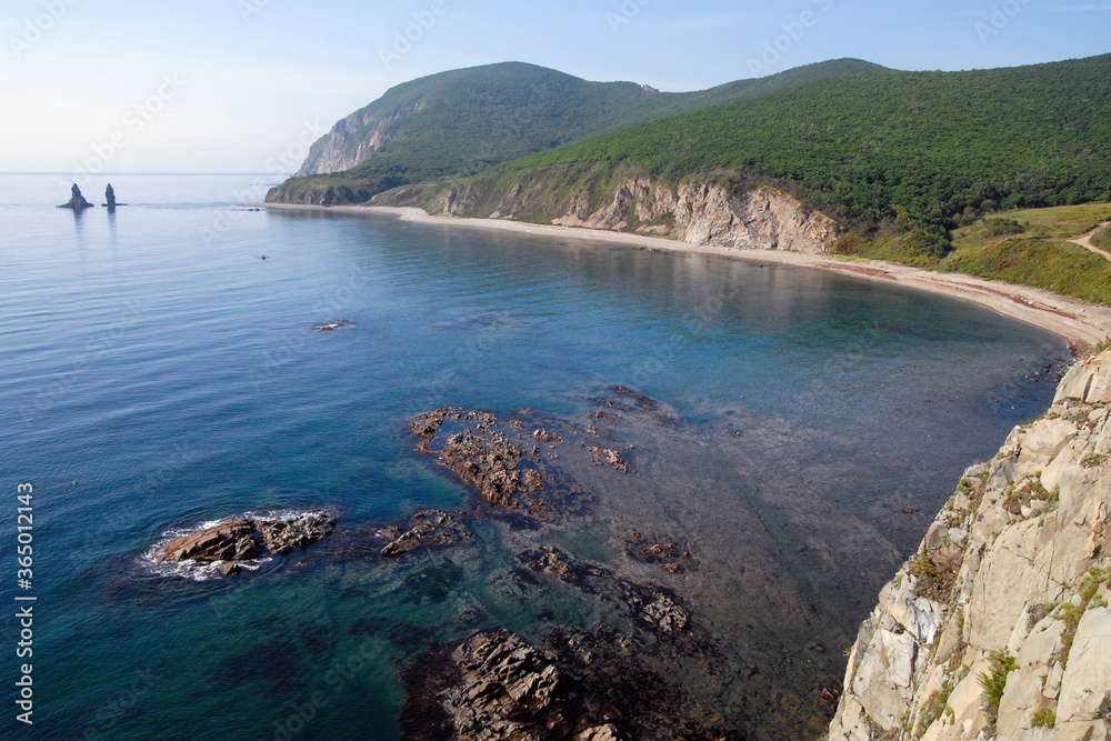 View at Rudnaya bay of Sea of Japan and Two Brothers (also Two Fingers) stack (or sea stack, rock, island). Outskirts of Rudnaya Pristan town, Primorsky Krai (Primorye), Far East, Russia.