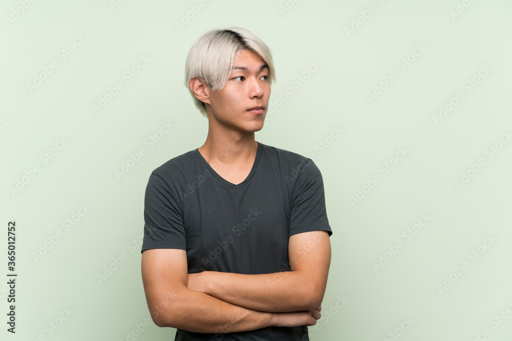 Obraz premium Young asian man over isolated green background portrait