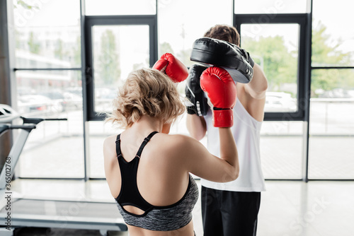 back view of sport couple in boxing gloves and pads exercising in gym © LIGHTFIELD STUDIOS