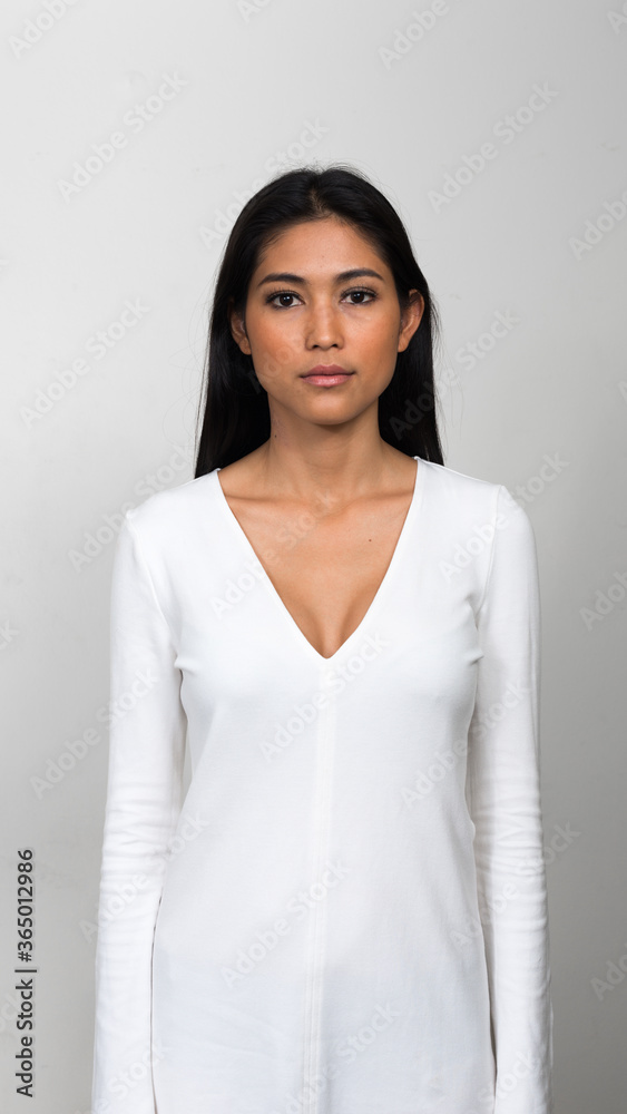 Portrait of young beautiful Asian woman against white background Portrait of young beautiful Asian woman against white background