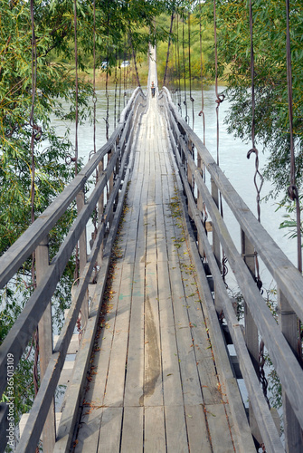 Fototapeta Naklejka Na Ścianę i Meble -  Wooden pedestrian bridge across Bolshaya Ussurka river. Dalniy Kut village, Primorsky Krai, Far East, Russia.