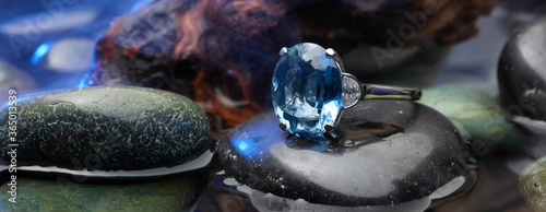 Classy blue gem ring close-up on top of black stone photo