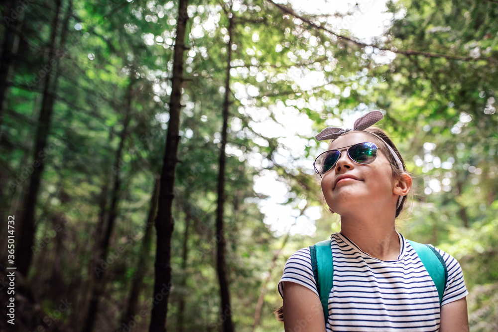Adorable little girl smiling while walking in a forest Adorable little girl smiling while walking in a forest