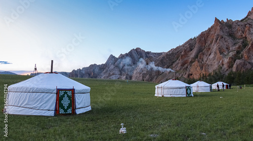 A row of Mongolian gers at a camp at sunset on a summers night