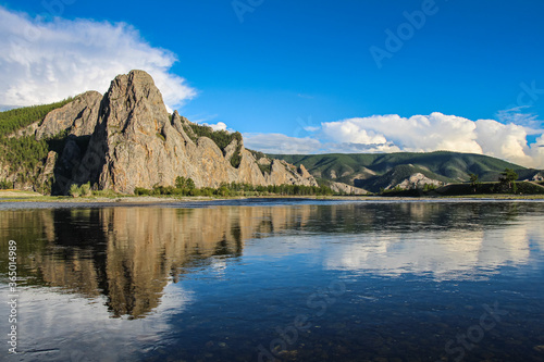 A Mongolian mountain reflecting on the Delger Murun River, in the evening sun photo