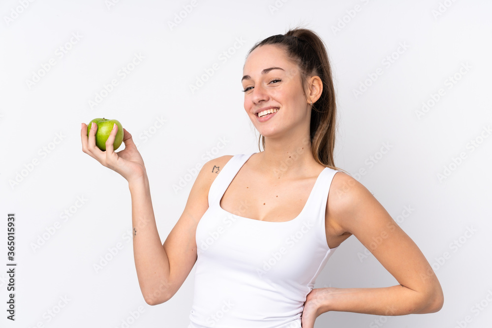 Young brunette woman over isolated white background with an apple and happy
