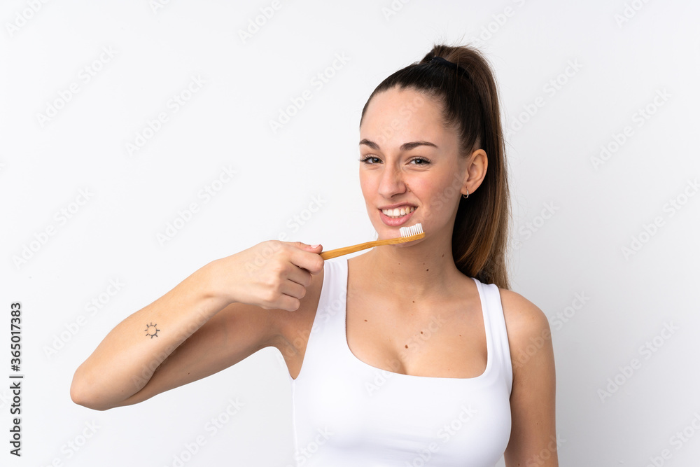 Young brunette woman over isolated white background with a toothbrush Young brunette woman over isolated white background with a toothbrush