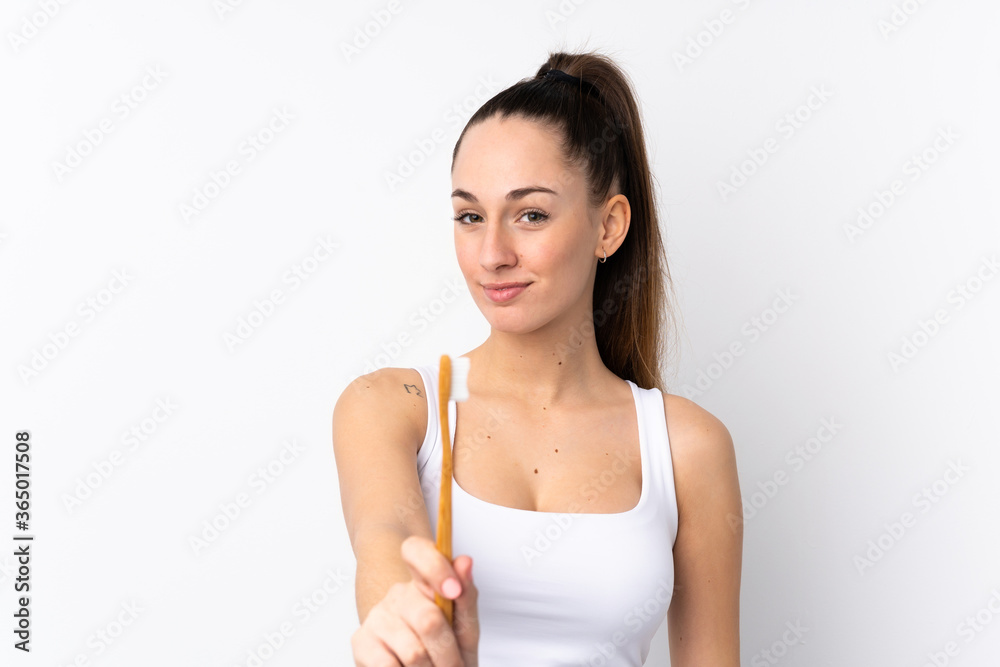Young brunette woman over isolated white background with a toothbrush Young brunette woman over isolated white background with a toothbrush