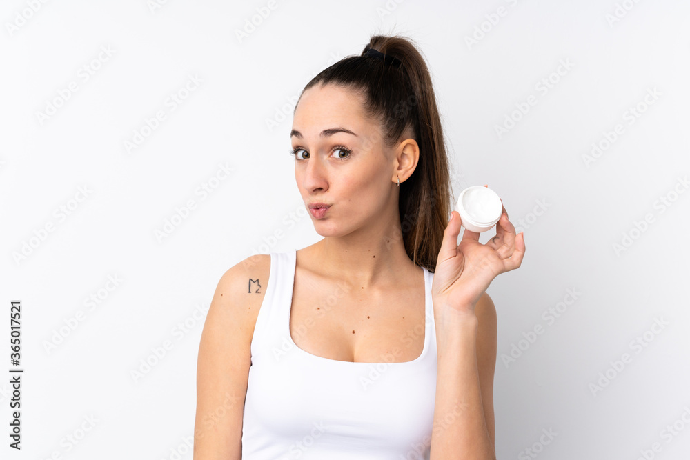 Young brunette woman over isolated white background with moisturizer Young brunette woman over isolated white background with moisturizer