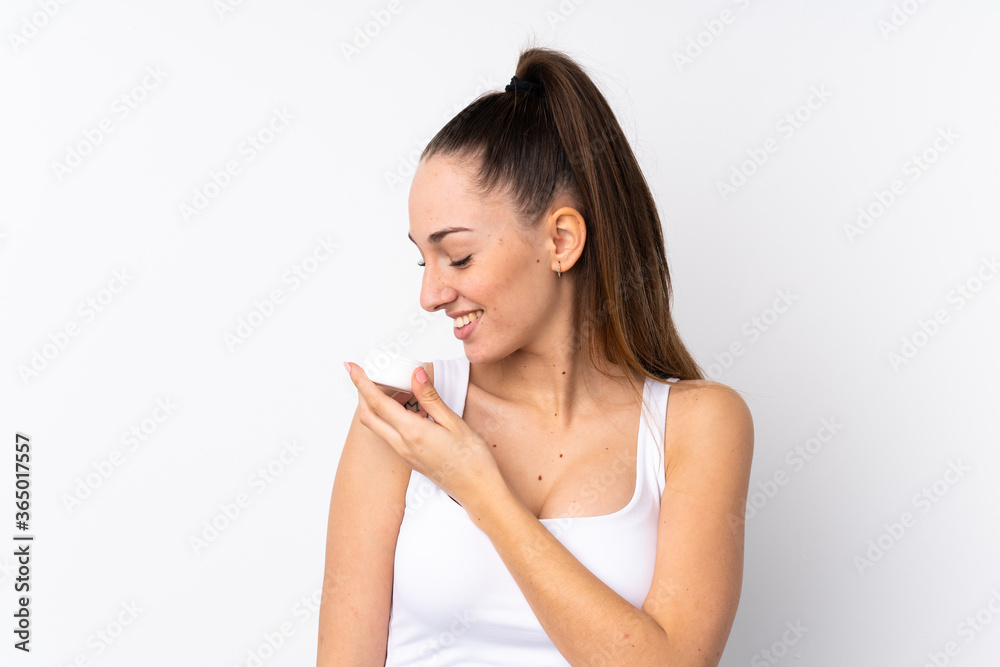 Young brunette woman over isolated white background with moisturizer and smelling it Young brunette woman over isolated white background with moisturizer and smelling it