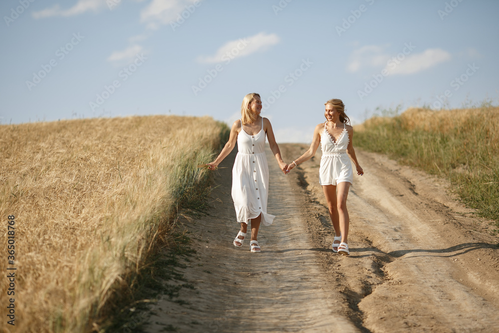 Adult mother with daughter. Beautiful girl in a white dress. Family in a summer field Adult mother with daughter. Beautiful girl in a white dress. Family in a summer field