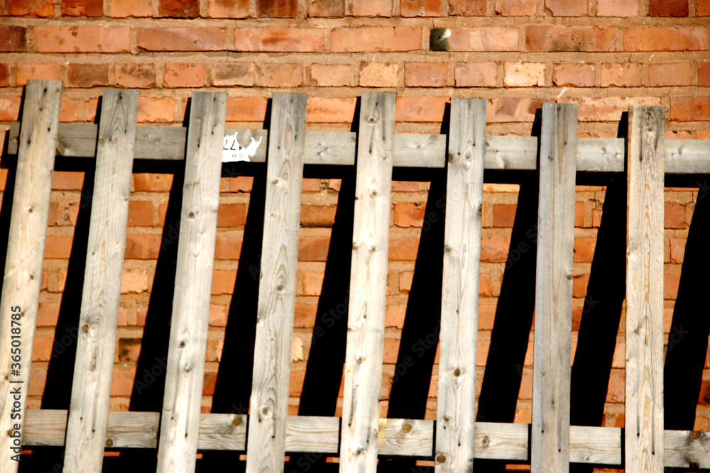 A Wooden Fence Against A Brick Wall