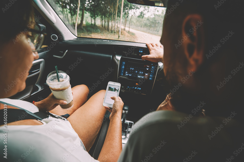 Φωτογραφία Back view of two tourists with milk shake sitting at helm of rented car and sear