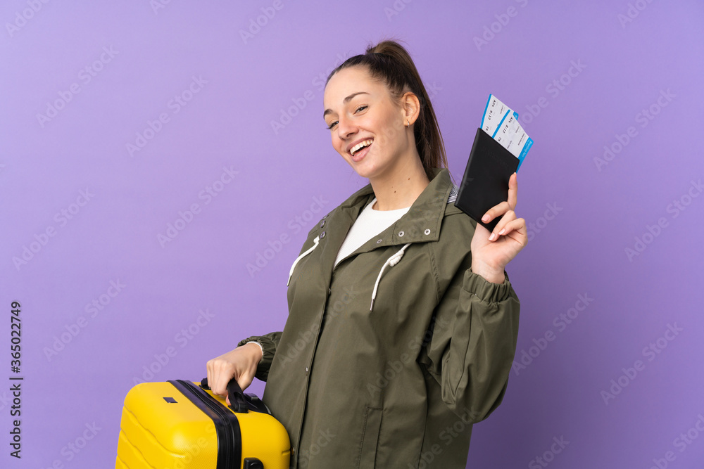 Young brunette woman over isolated purple background in vacation with suitcase and passport Young brunette woman over isolated purple background in vacation with suitcase and passport