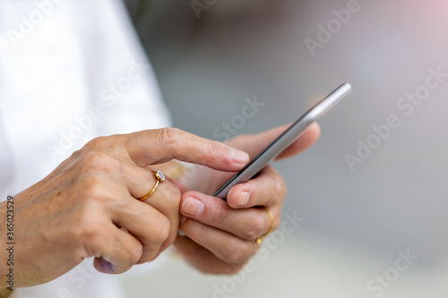 Senior woman s hands holding a smart phone 