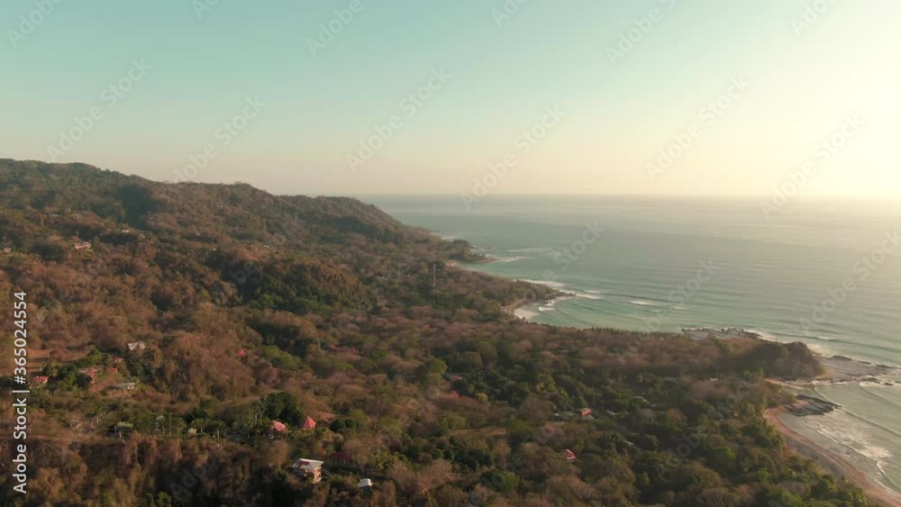 Aerial forward tilt shot of waves breaking on Costa Rica coastline in sunset Aerial forward tilt shot of waves breaking on Costa Rica coastline in sunset