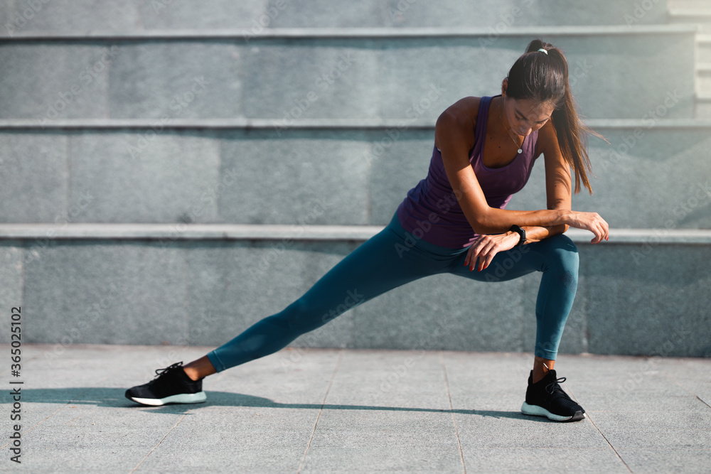 Fototapeta premium Young woman doing a leg stretching exercise