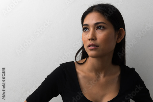 Portrait of young beautiful Asian businesswoman against white background